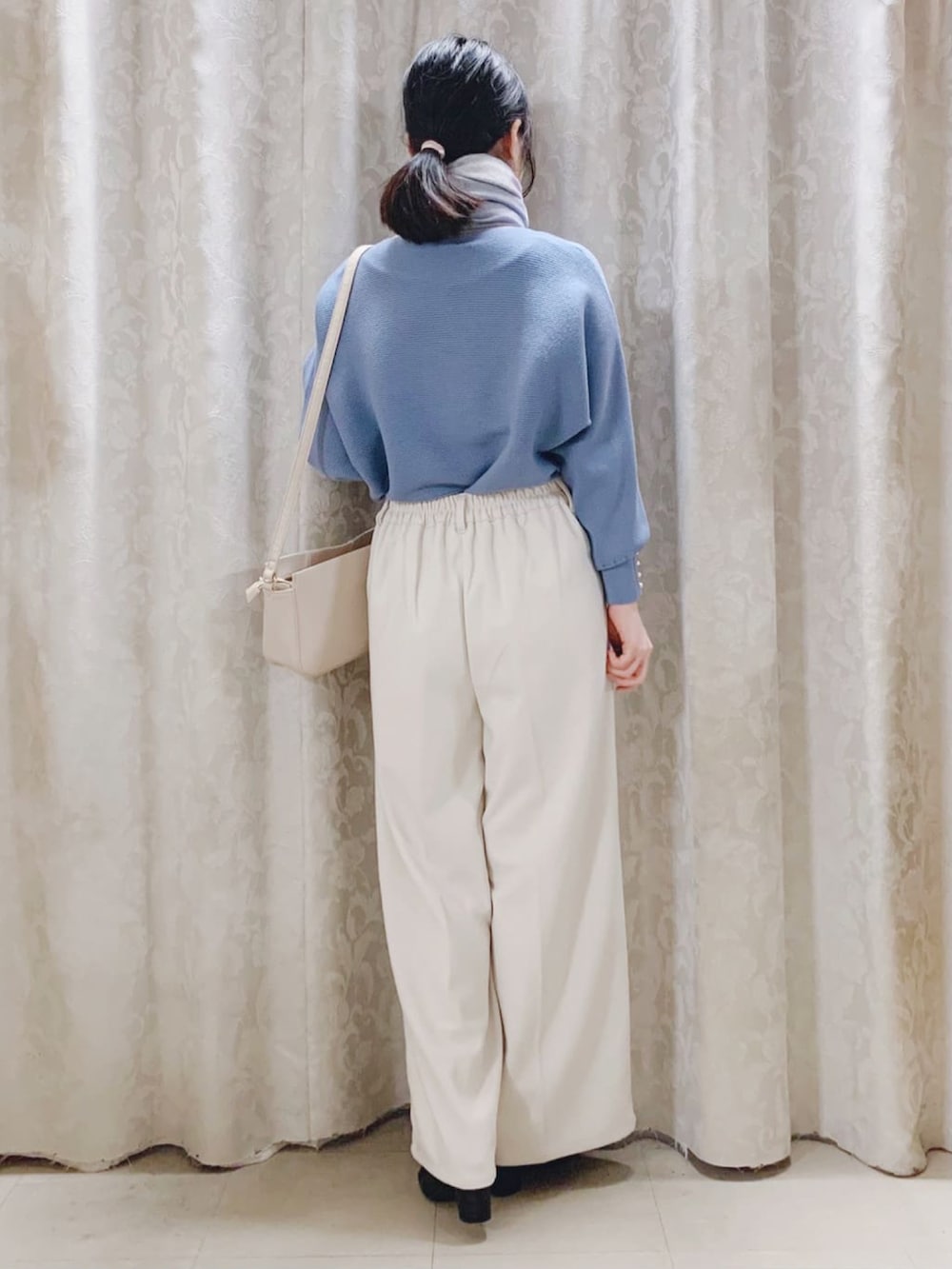 ブルー系のニット/セーター、ベージュ系のその他パンツ、ブラック系のブーツを着用したレディースの冬コーディネートの3枚目の写真