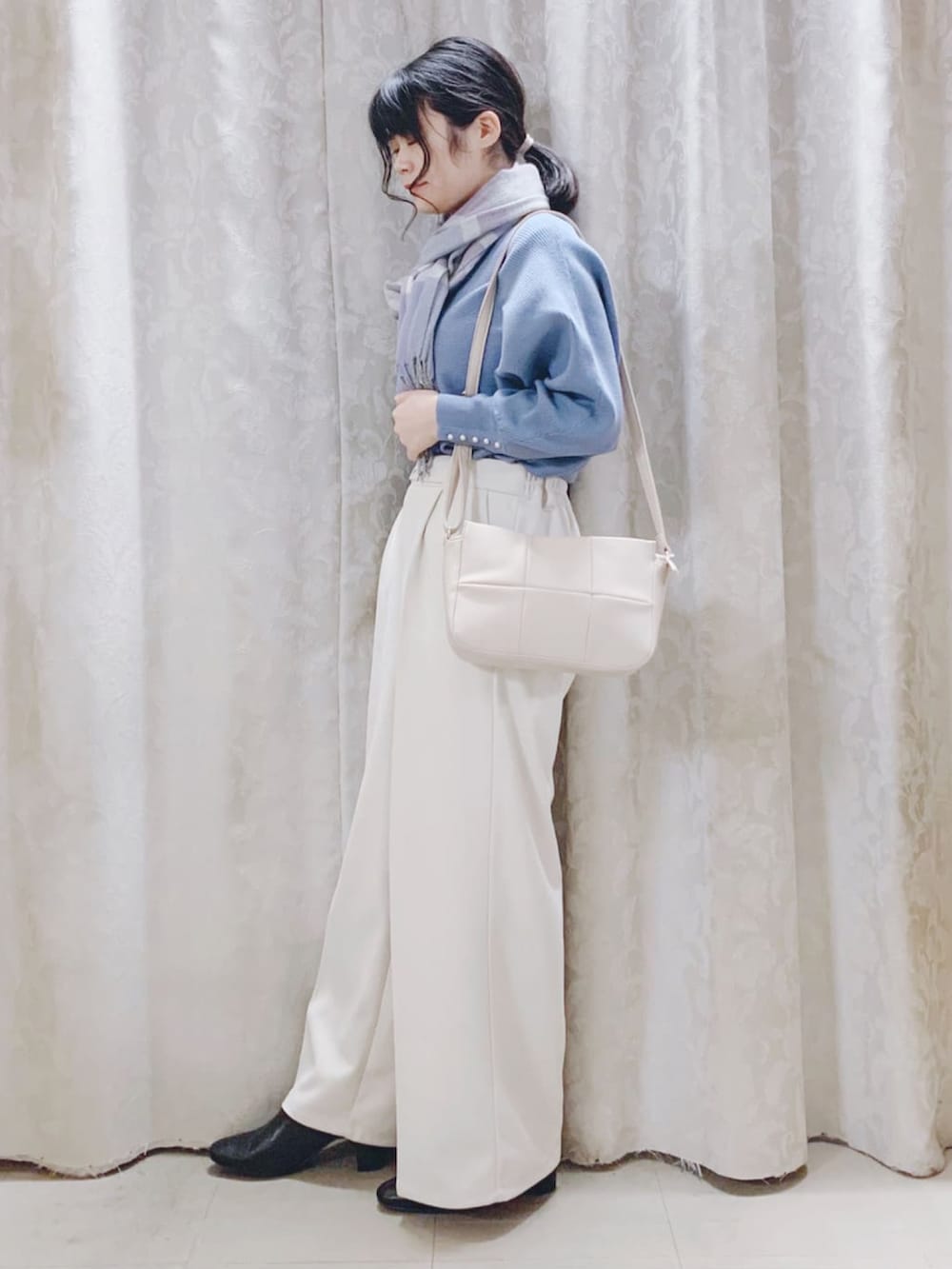 ブルー系のニット/セーター、ベージュ系のその他パンツ、ブラック系のブーツを着用したレディースの冬コーディネートの2枚目の写真