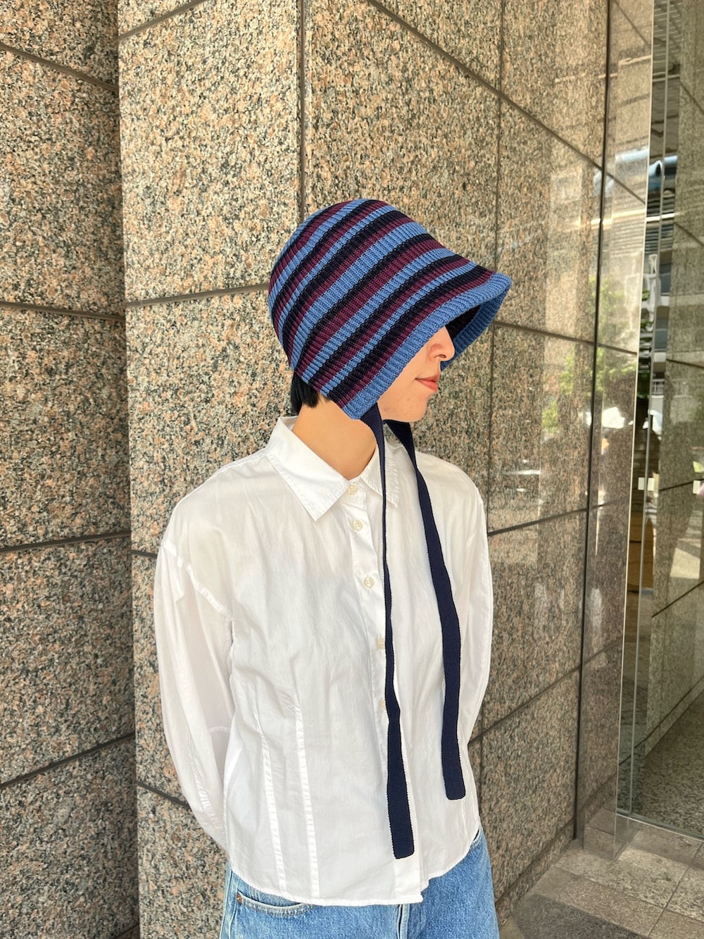 ホワイト系のシャツ/ブラウス、ブラック系のスニーカー、ブルー系のハットを着用したレディースの夏コーディネートの2枚目の写真