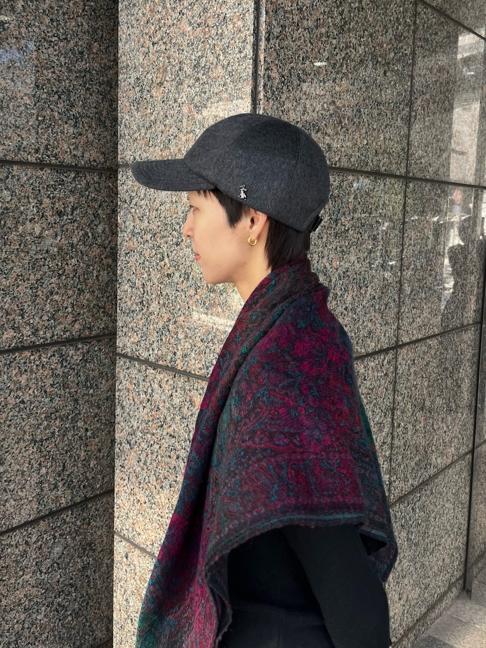 グレー系のデニムパンツ、ブラック系のブーツ、グレー系のキャップを着用したレディースの冬コーディネートの3枚目の写真