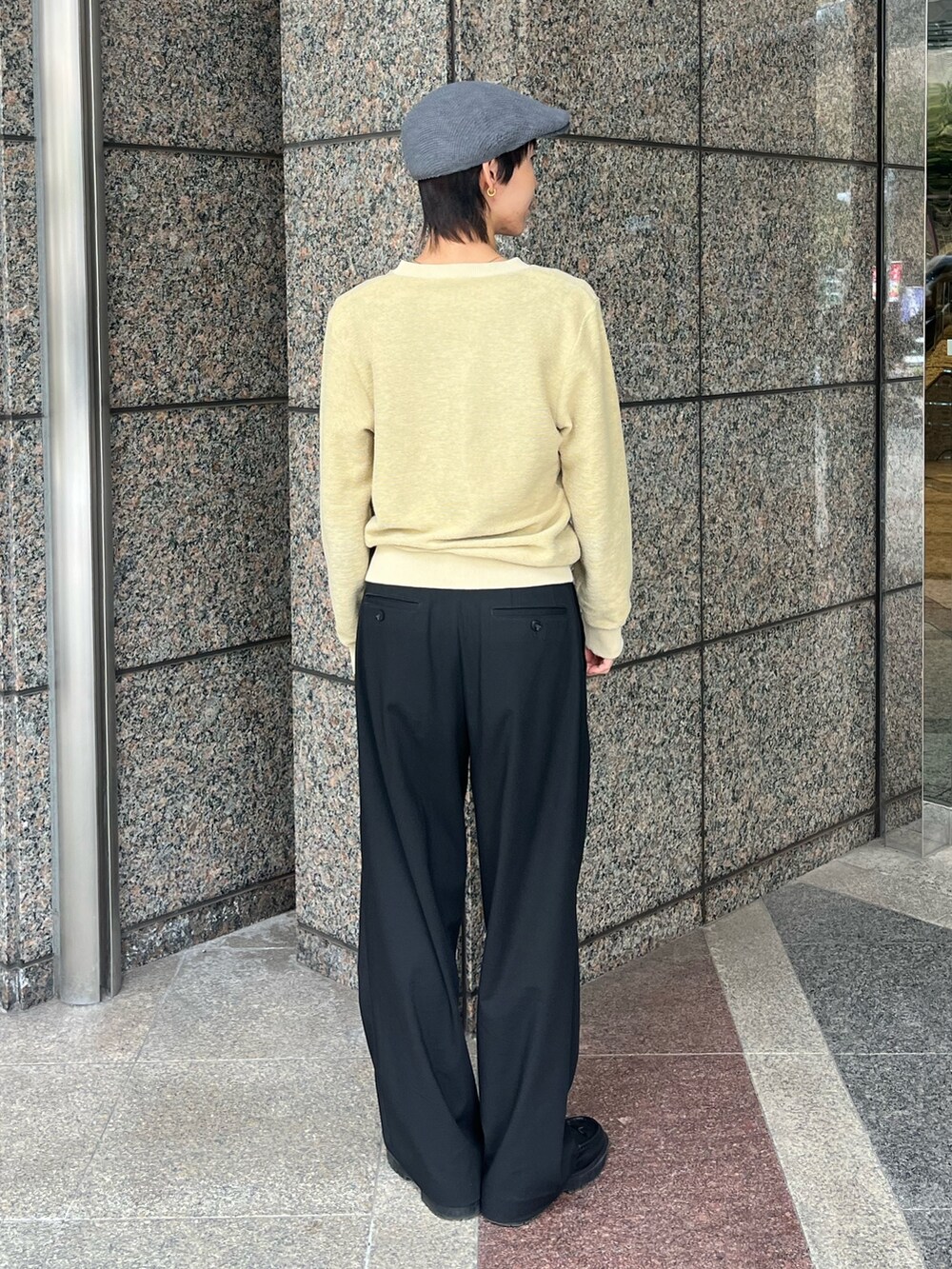 イエロー系のトップス、ブラック系のスラックス、ブラック系のローファーを着用したレディースの冬コーディネートの2枚目の写真