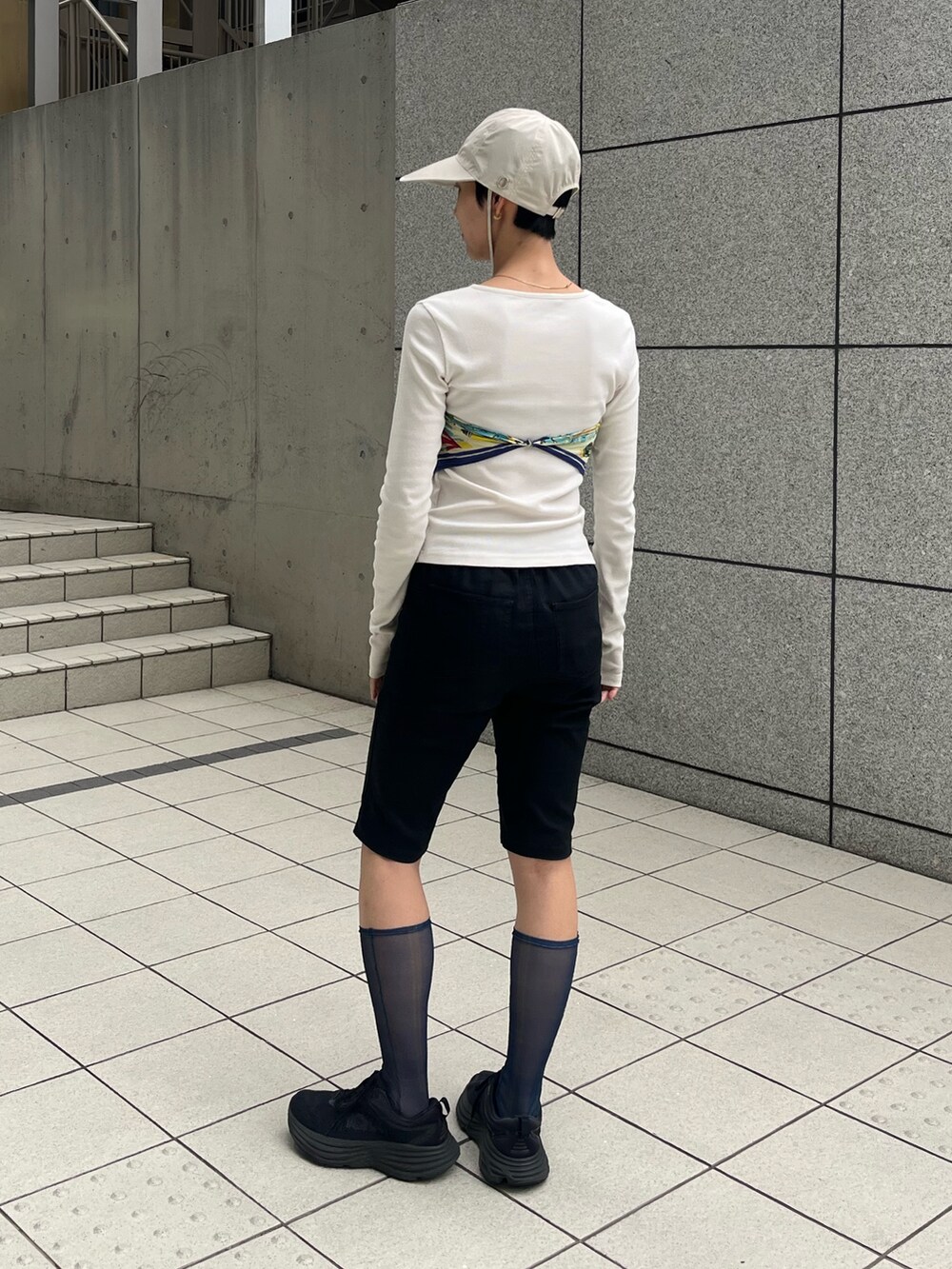 ブラック系のスニーカー、ベージュ系のキャップ、ブルー系のソックス/靴下を着用したレディースの春コーディネートの2枚目の写真