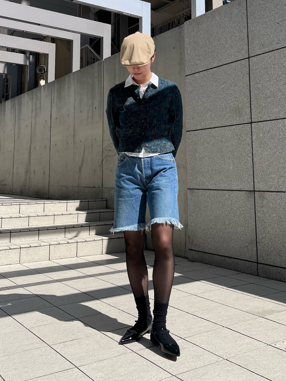 ブルー系のデニムパンツ、グリーン系のジャケット/アウター、ブラック系のパンプスを着用したレディースの春コーディネートの2枚目の写真