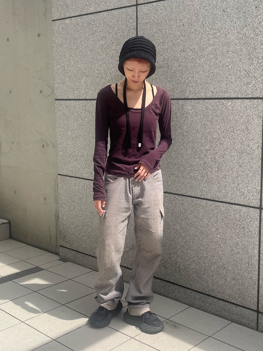 グレー系のデニムパンツ、ブラック系のスニーカー、ブラック系のニットキャップ/ビーニーを着用したレディースの秋コーディネートの3枚目の写真