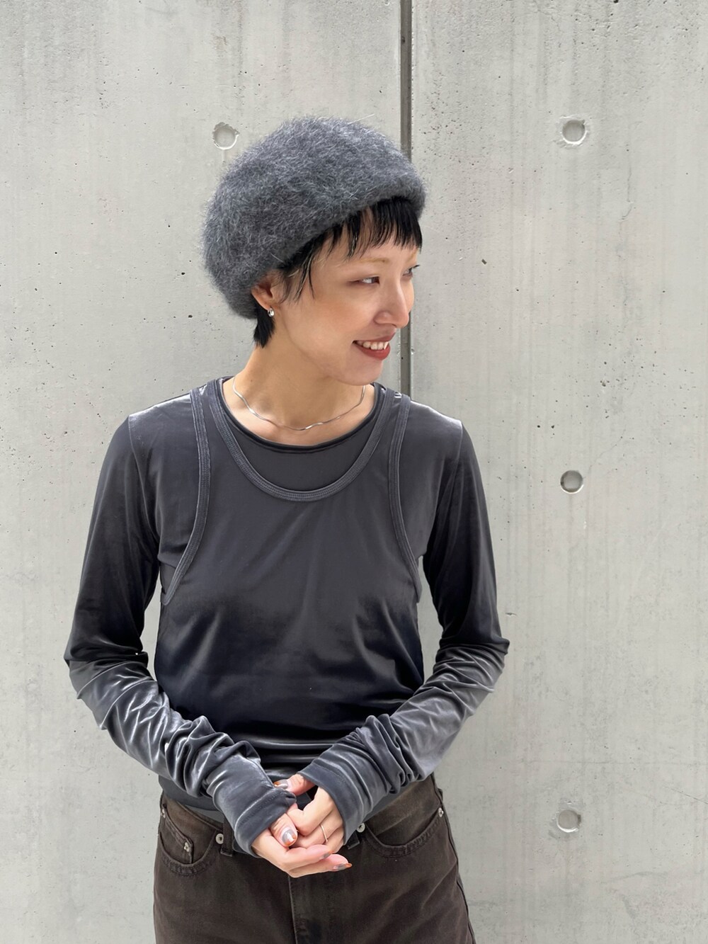 グレー系のTシャツ/カットソー、グレー系のタンクトップ、ブラウン系のデニムパンツを着用したレディースの秋コーディネートの2枚目の写真