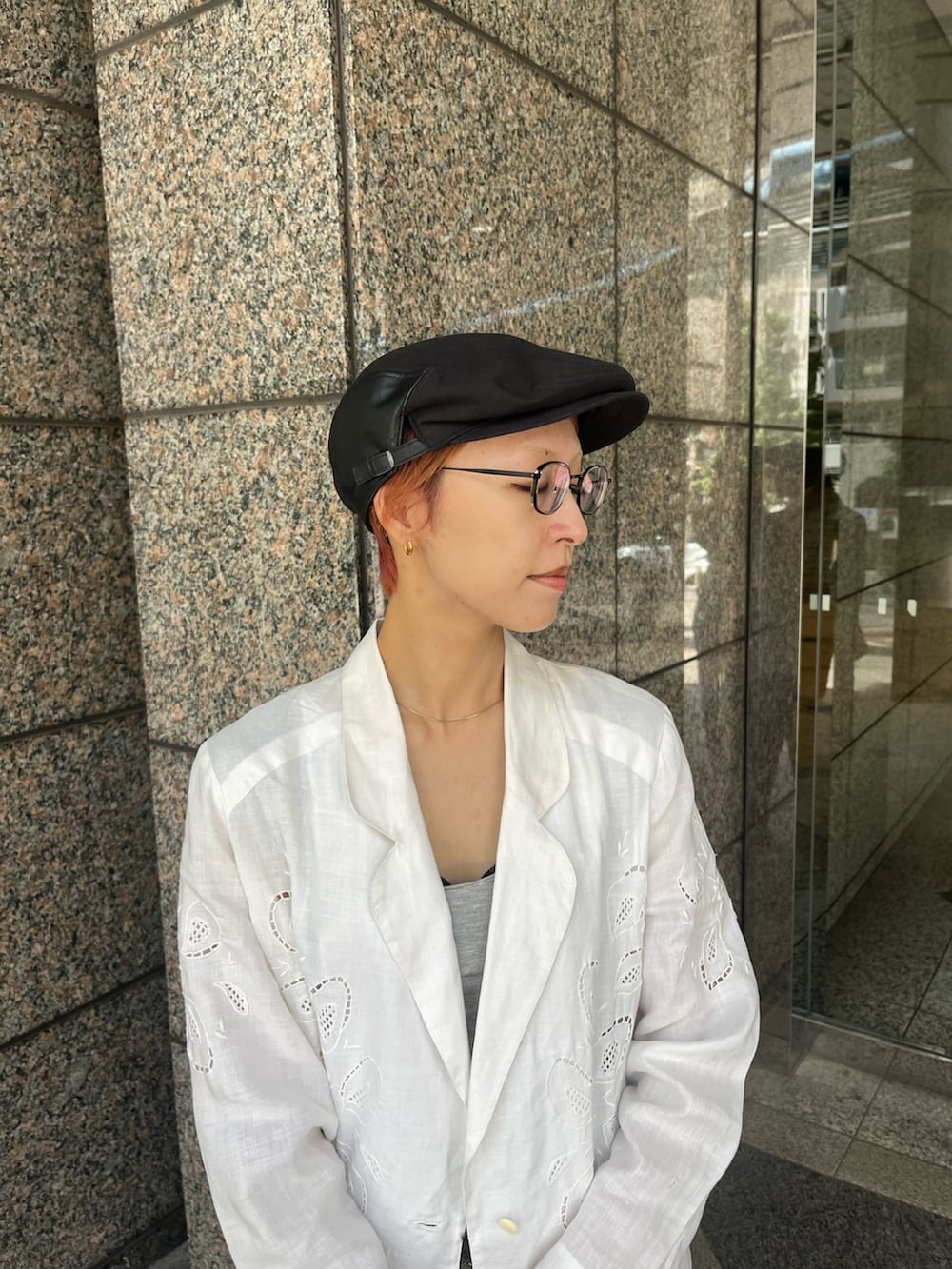 ブラック系のスニーカー、ホワイト系のジャケット/アウター、ブラック系のハンチング/ベレー帽を着用したレディースの秋コーディネートの2枚目の写真