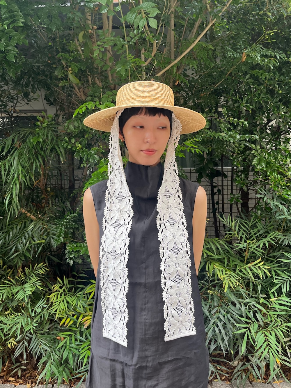 ブラウン系のデニムパンツ、ブラック系のタンクトップ、ブラック系のサンダルを着用したレディースの夏コーディネートの2枚目の写真