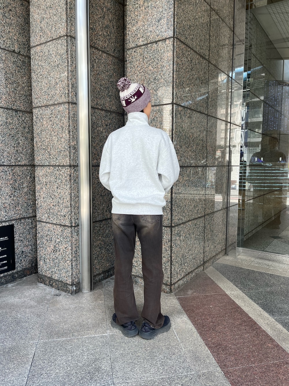 レッド系のニットキャップ/ビーニーを着用したレディースの冬コーディネートの2枚目の写真