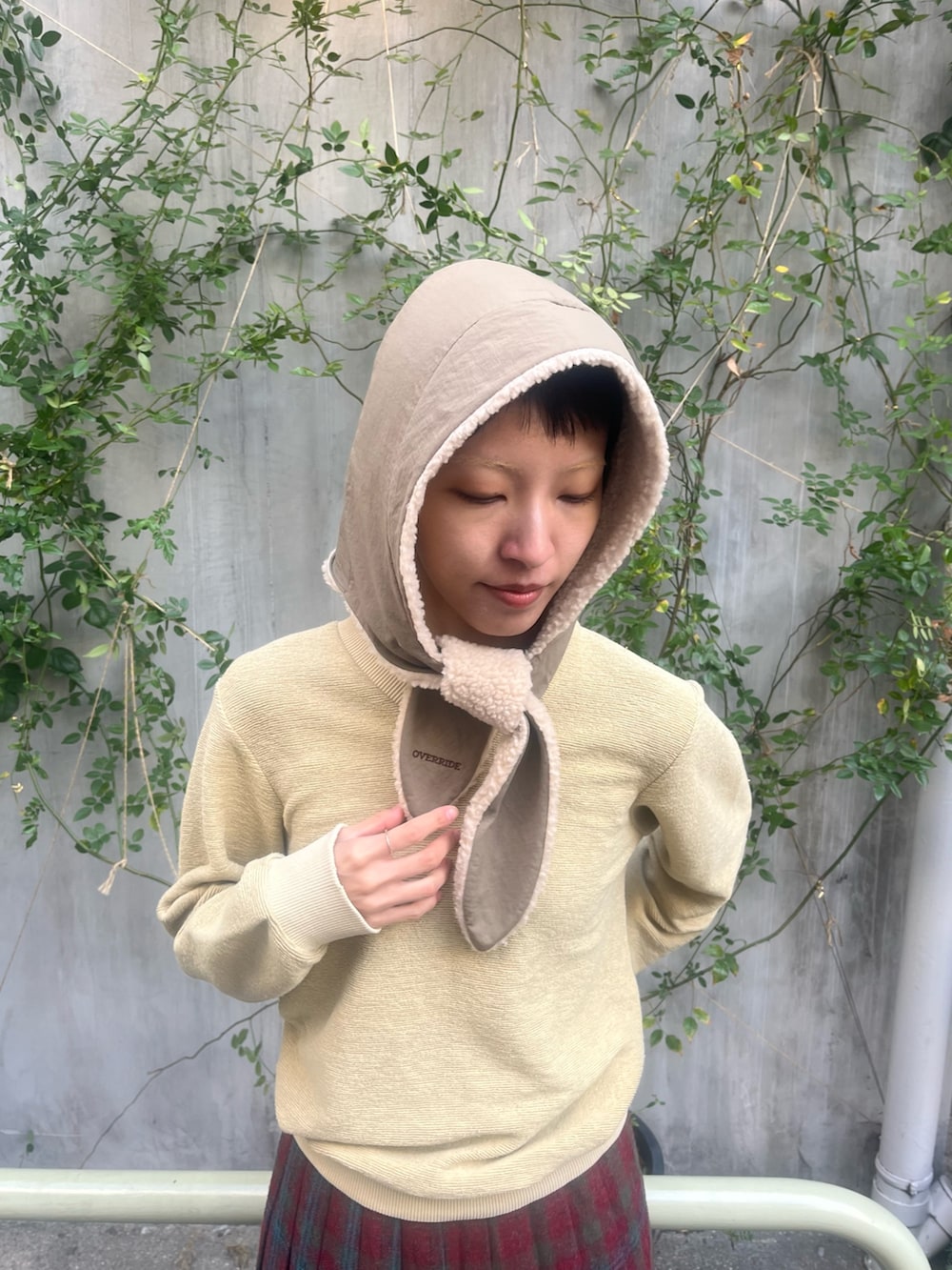 イエロー系のトップス、レッド系のスカート、ブラウン系のデニムパンツを着用したレディースの冬コーディネートの3枚目の写真
