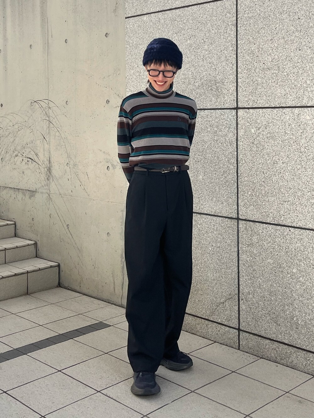 ブラック系のスラックス、ブラック系のスニーカー、その他のTシャツ/カットソーを着用したレディースの冬コーディネートの2枚目の写真