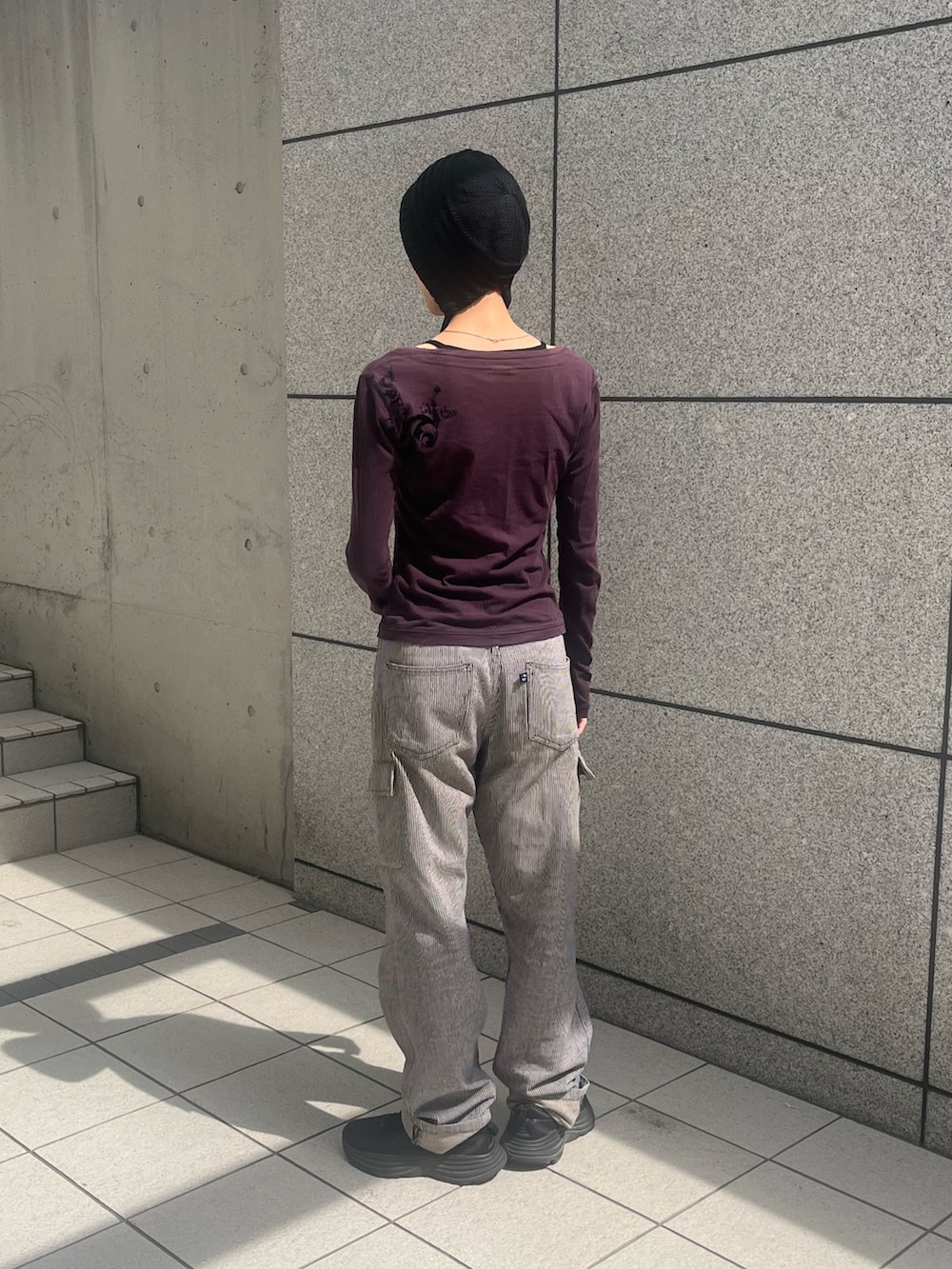 グレー系のデニムパンツ、ブラック系のスニーカー、ブラック系のニットキャップ/ビーニーを着用したレディースの秋コーディネートの2枚目の写真