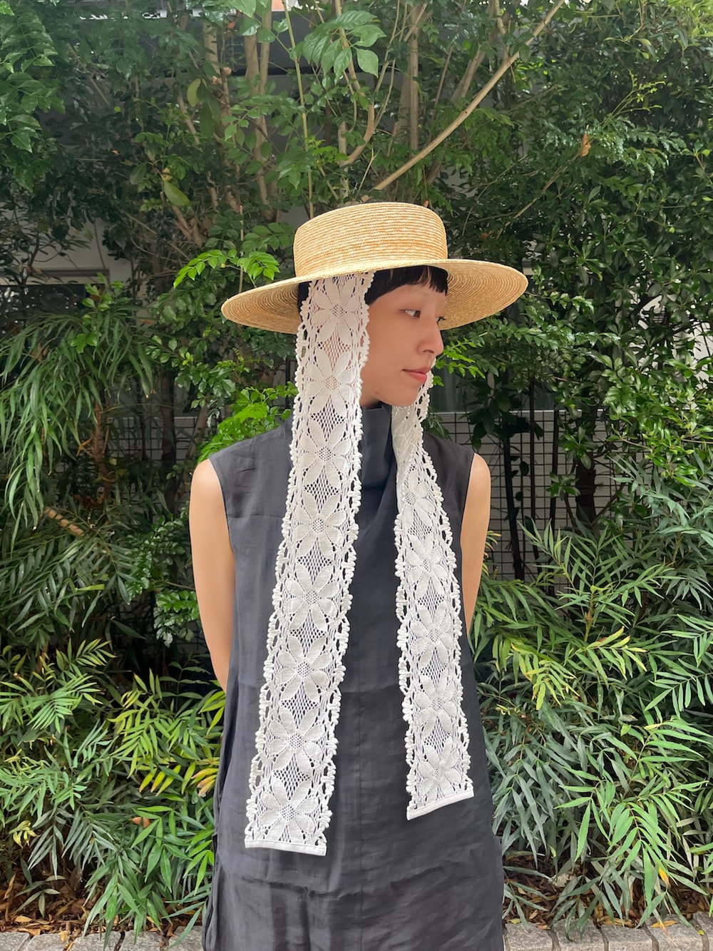 ブラウン系のデニムパンツ、ブラック系のタンクトップ、ブラック系のサンダルを着用したレディースの夏コーディネートの3枚目の写真