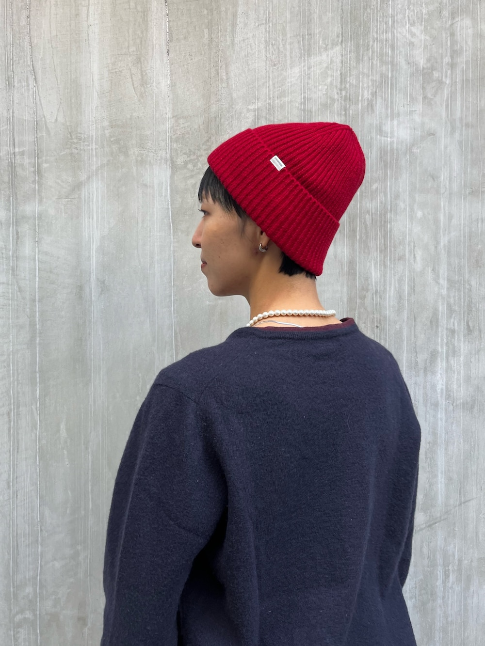 ブルー系のニット/セーター、ブラウン系のデニムパンツ、ブラック系のスニーカーを着用したレディースの秋コーディネートの2枚目の写真