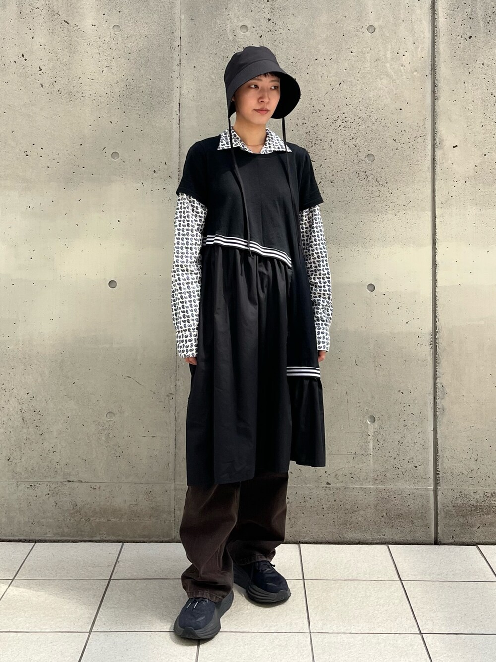 ブラック系のスニーカー、ブルー系のシャツ/ブラウス、ブラック系のハットを着用したレディースの春コーディネートの2枚目の写真