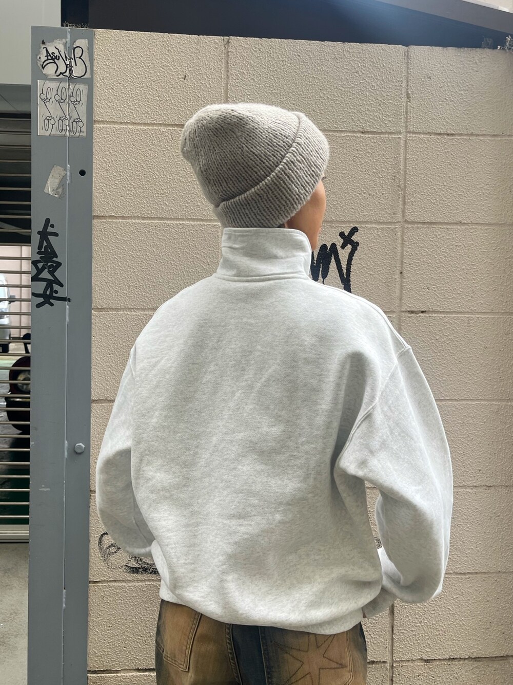 ブラウン系のデニムパンツ、ブラック系のスニーカー、グレー系のニットキャップ/ビーニーを着用したレディースの秋コーディネートの4枚目の写真