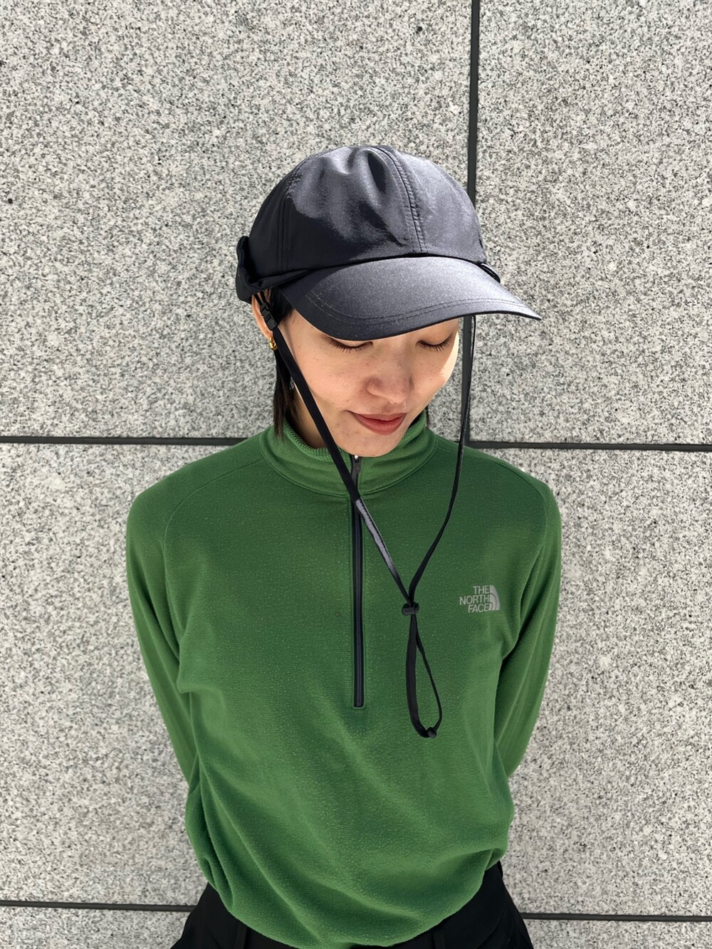 ブラック系のキャップを着用したレディースの春コーディネートの2枚目の写真