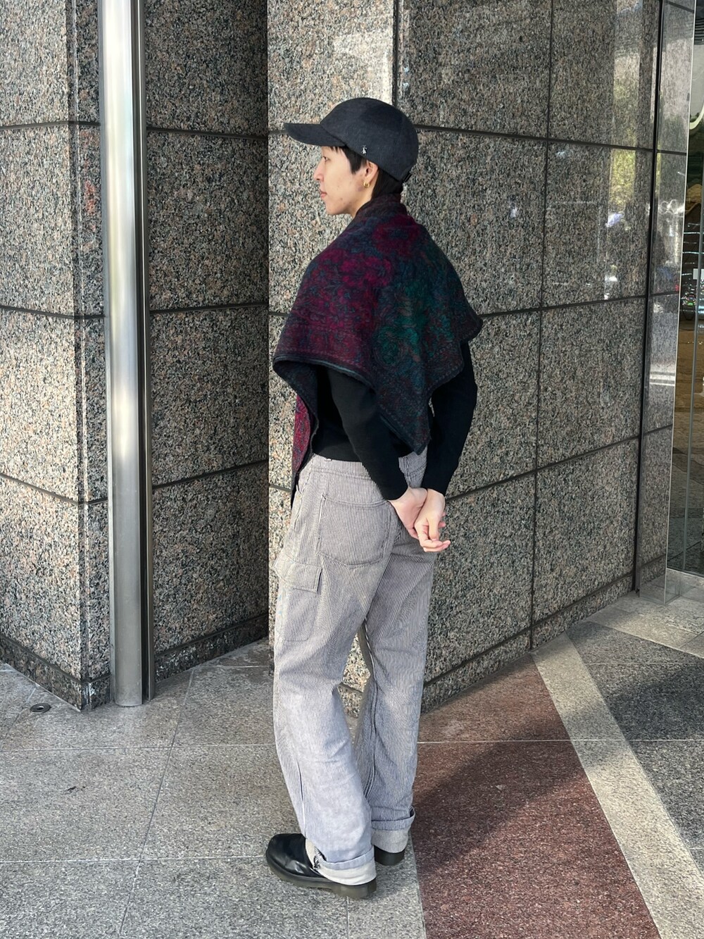 グレー系のデニムパンツ、ブラック系のブーツ、グレー系のキャップを着用したレディースの冬コーディネートの2枚目の写真