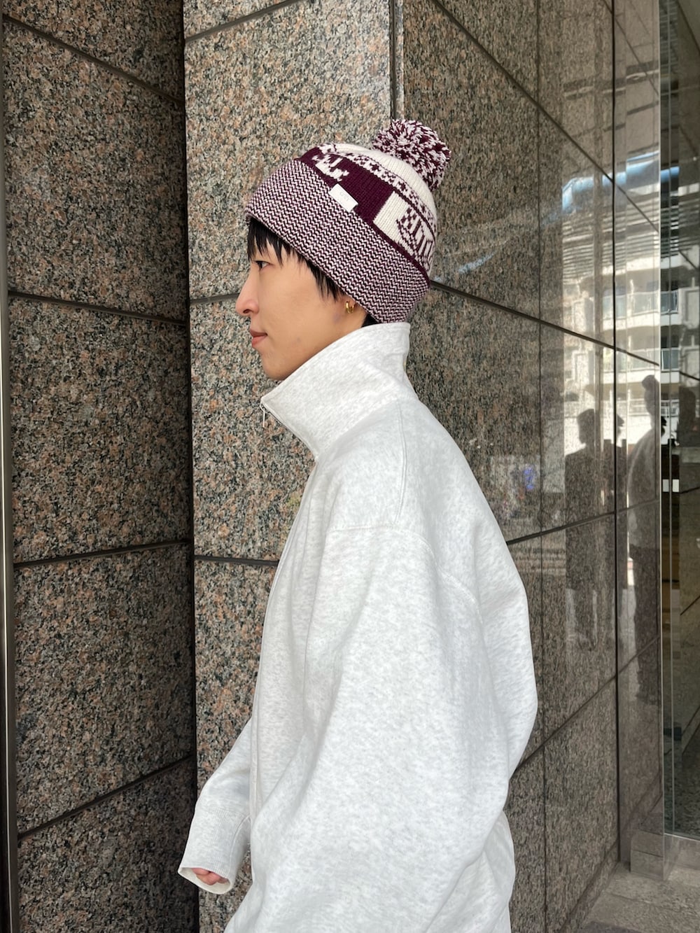 レッド系のニットキャップ/ビーニーを着用したレディースの冬コーディネートの3枚目の写真