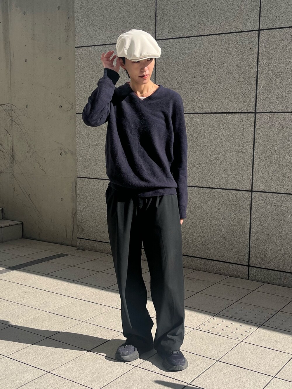 ブルー系のニット/セーター、ブラック系のスラックス、ブラック系のスニーカーを着用したレディースの秋コーディネートの2枚目の写真