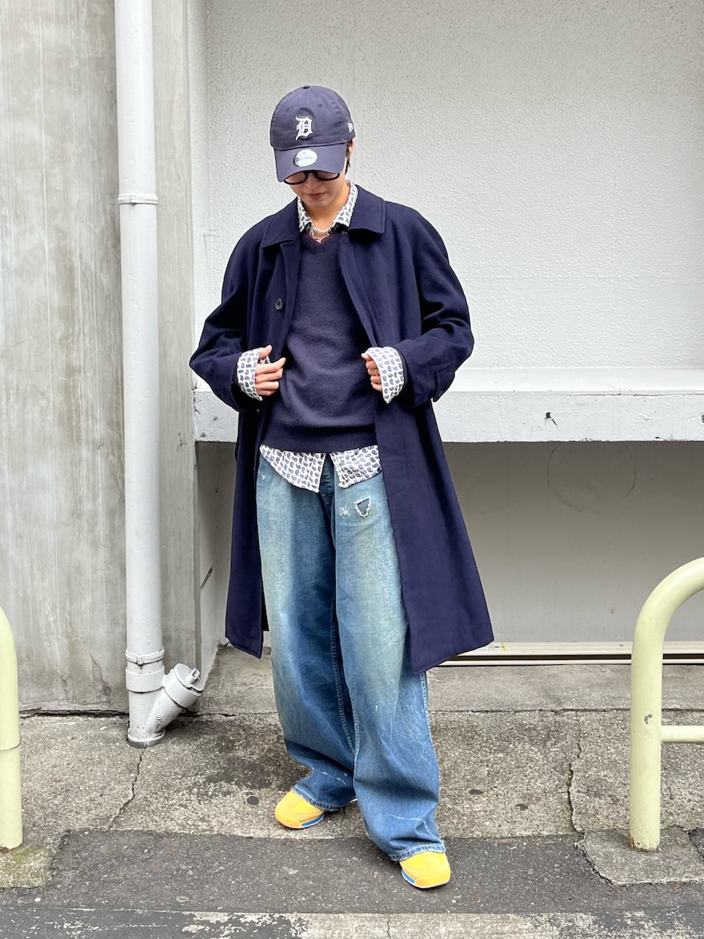 ブルー系のノーカラーコート、ブルー系のデニムパンツ、イエロー系のスニーカーを着用したレディースの冬コーディネートの2枚目の写真