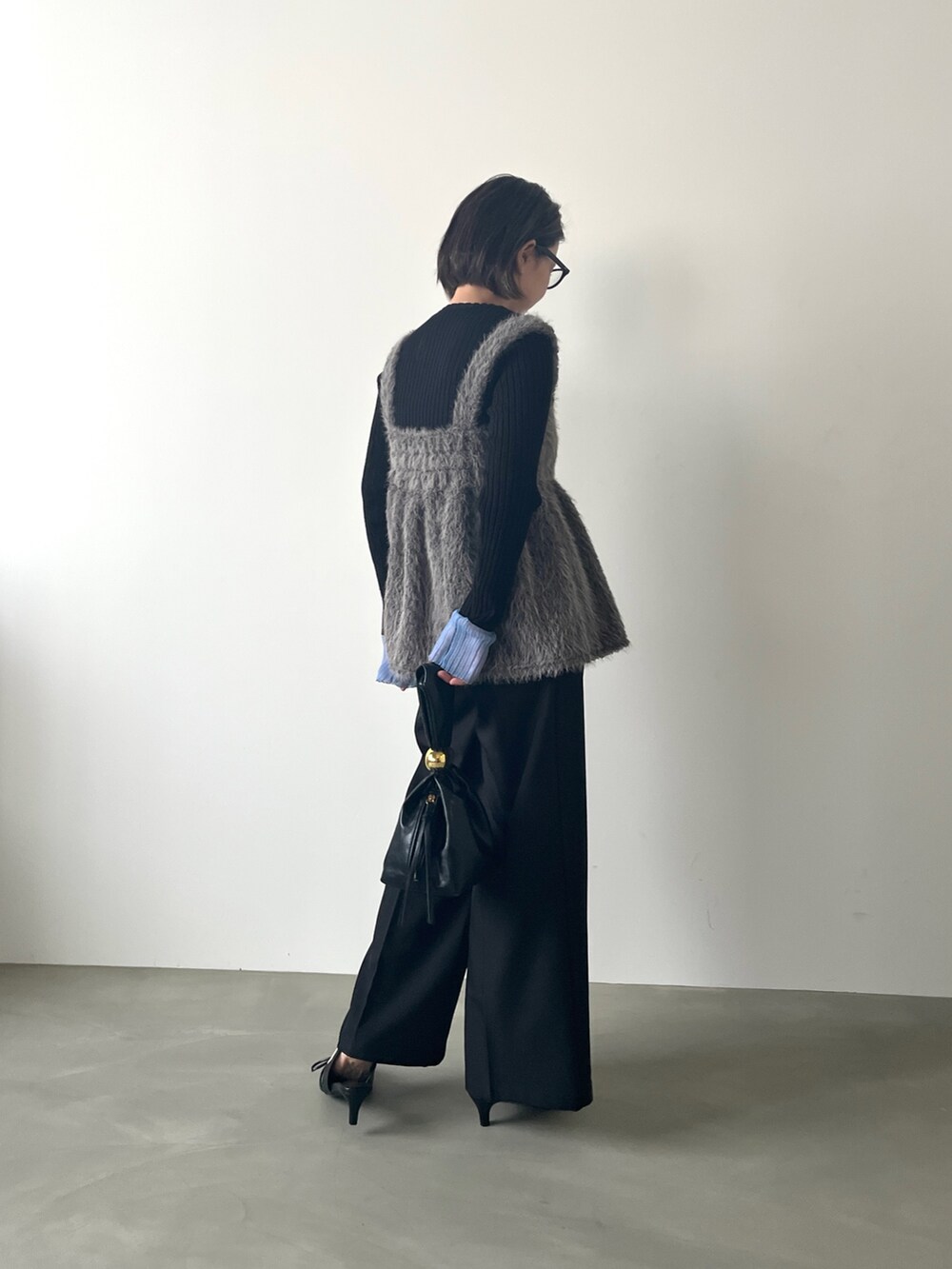 グレー系のTシャツ/カットソー、ブラック系のニット/セーターを着用したレディースの秋コーディネートの3枚目の写真