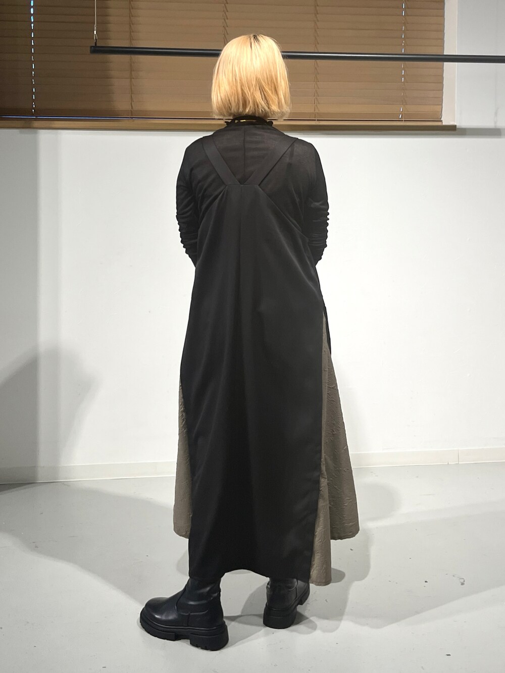 ブラック系のジャンパースカート、ブラック系のブーツ、ブラック系のTシャツ/カットソーを着用したレディースの秋コーディネートの3枚目の写真