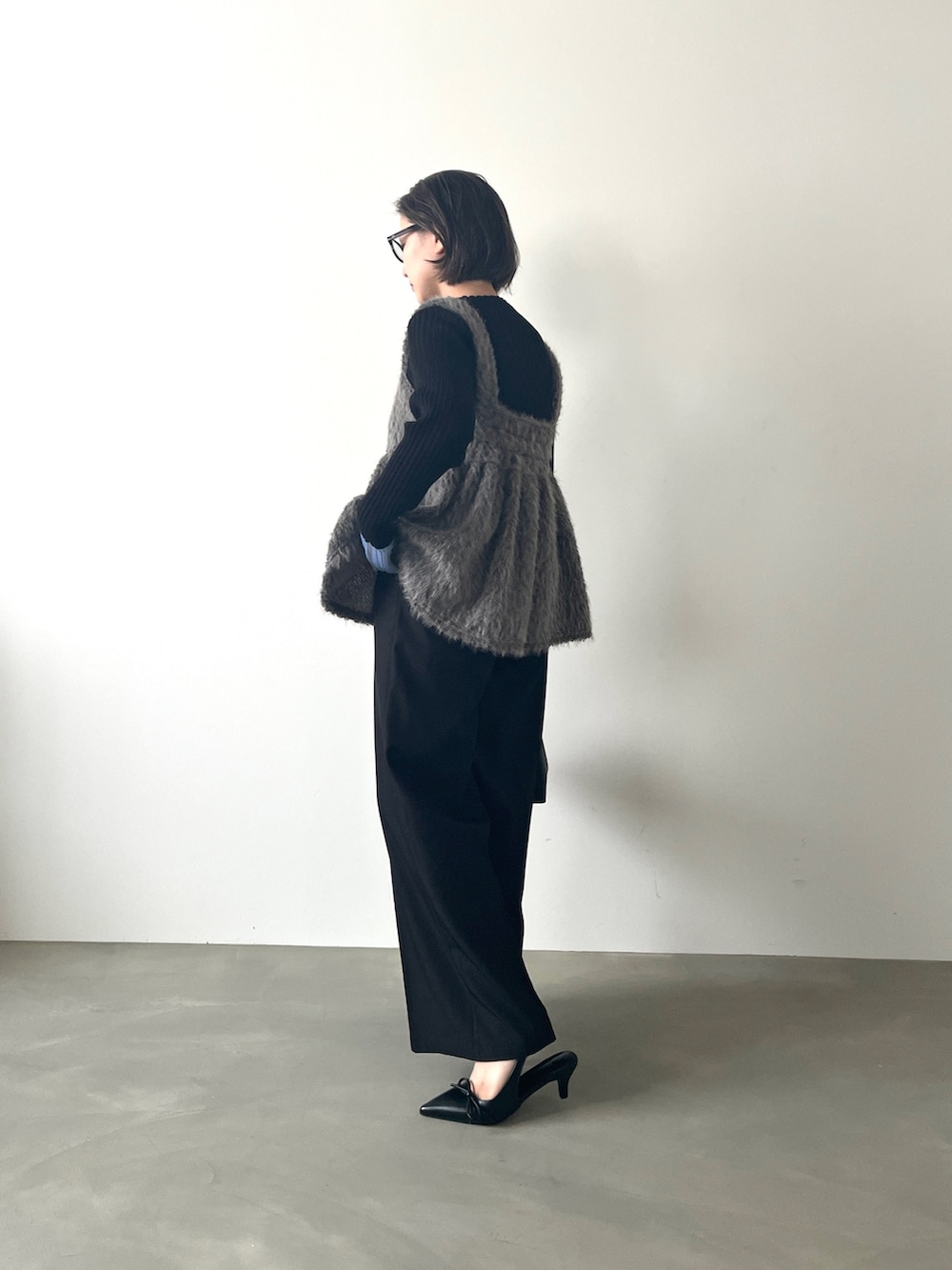 グレー系のTシャツ/カットソー、ブラック系のニット/セーターを着用したレディースの秋コーディネートの2枚目の写真