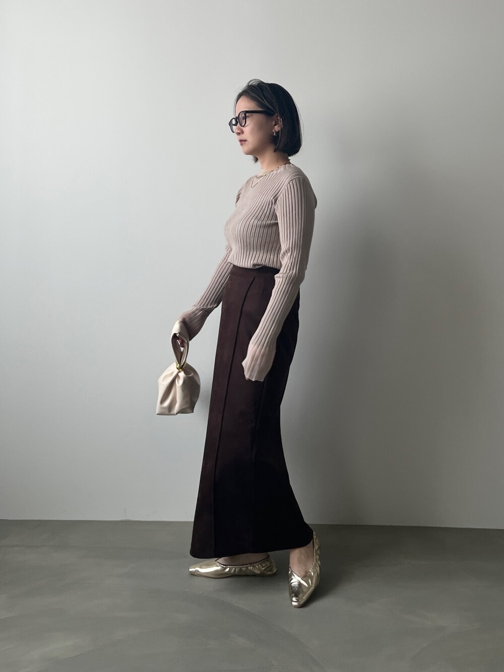 ブラック系のニット/セーター、ブラウン系のスカートを着用したレディースの秋コーディネートの2枚目の写真