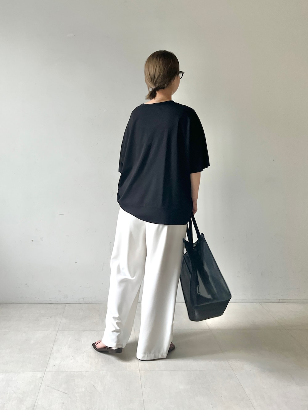 ブラック系のTシャツ/カットソー、ホワイト系のその他パンツ、ブラック系のトートバッグを着用したレディースの夏コーディネートの3枚目の写真