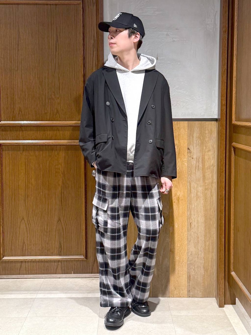 ブラック系のテーラードジャケット、グレー系のカーゴパンツ、グレー系のパーカーを着用したメンズの冬コーディネートの2枚目の写真