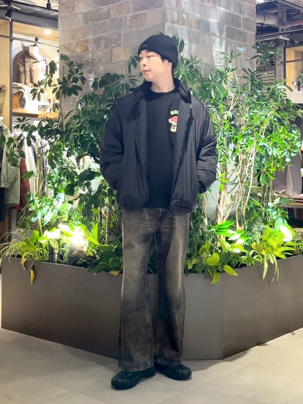 ブラック系のダウンジャケット/コート、グレー系のデニムパンツ、ブラック系のニット/セーターを着用したメンズの冬コーディネートの2枚目の写真