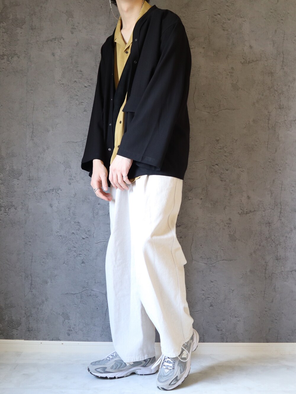 イエロー系のシャツ/ブラウス、ブラック系のカーディガン/ボレロ、ホワイト系のスラックスを着用したメンズの春コーディネートの3枚目の写真