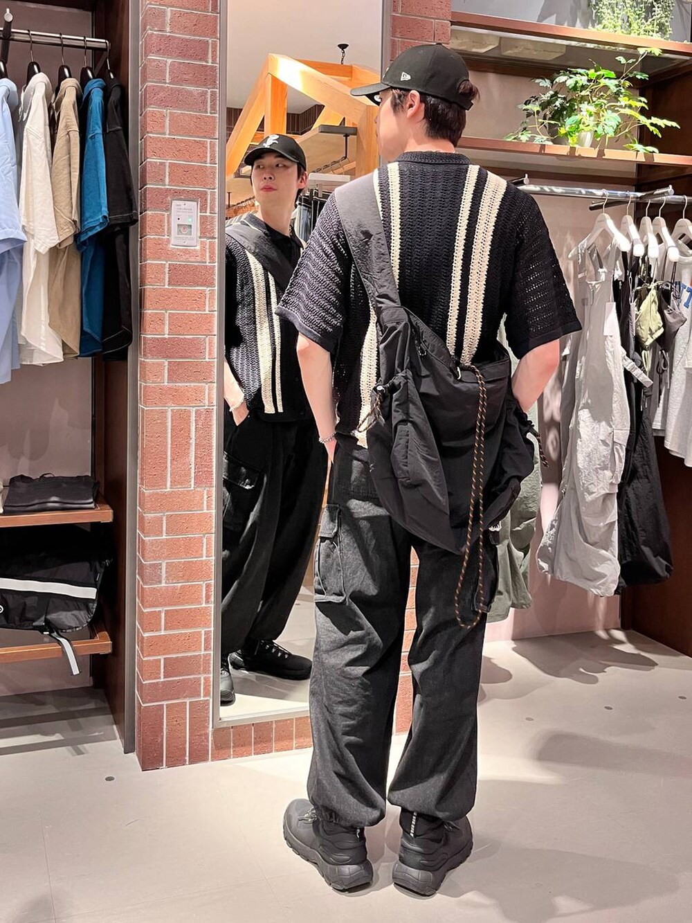 グレー系のデニムパンツ、ブラック系のショルダーバッグ、ブラック系のニット/セーターを着用したメンズの夏コーディネートの3枚目の写真