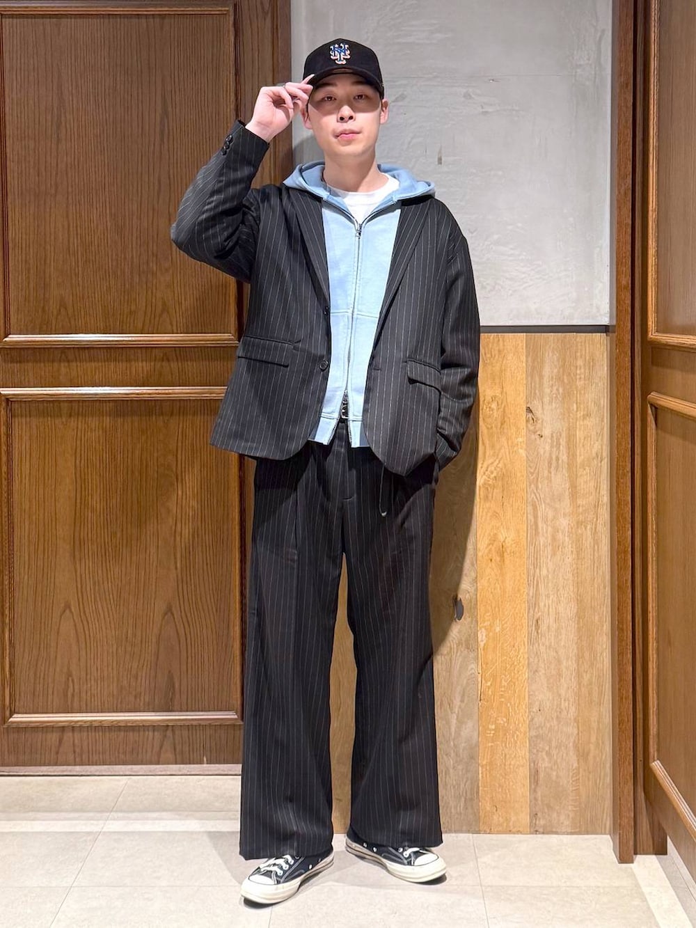 ブラック系のスラックス、ブラック系のテーラードジャケット、ブルー系のパーカーを着用したメンズの冬コーディネートの2枚目の写真