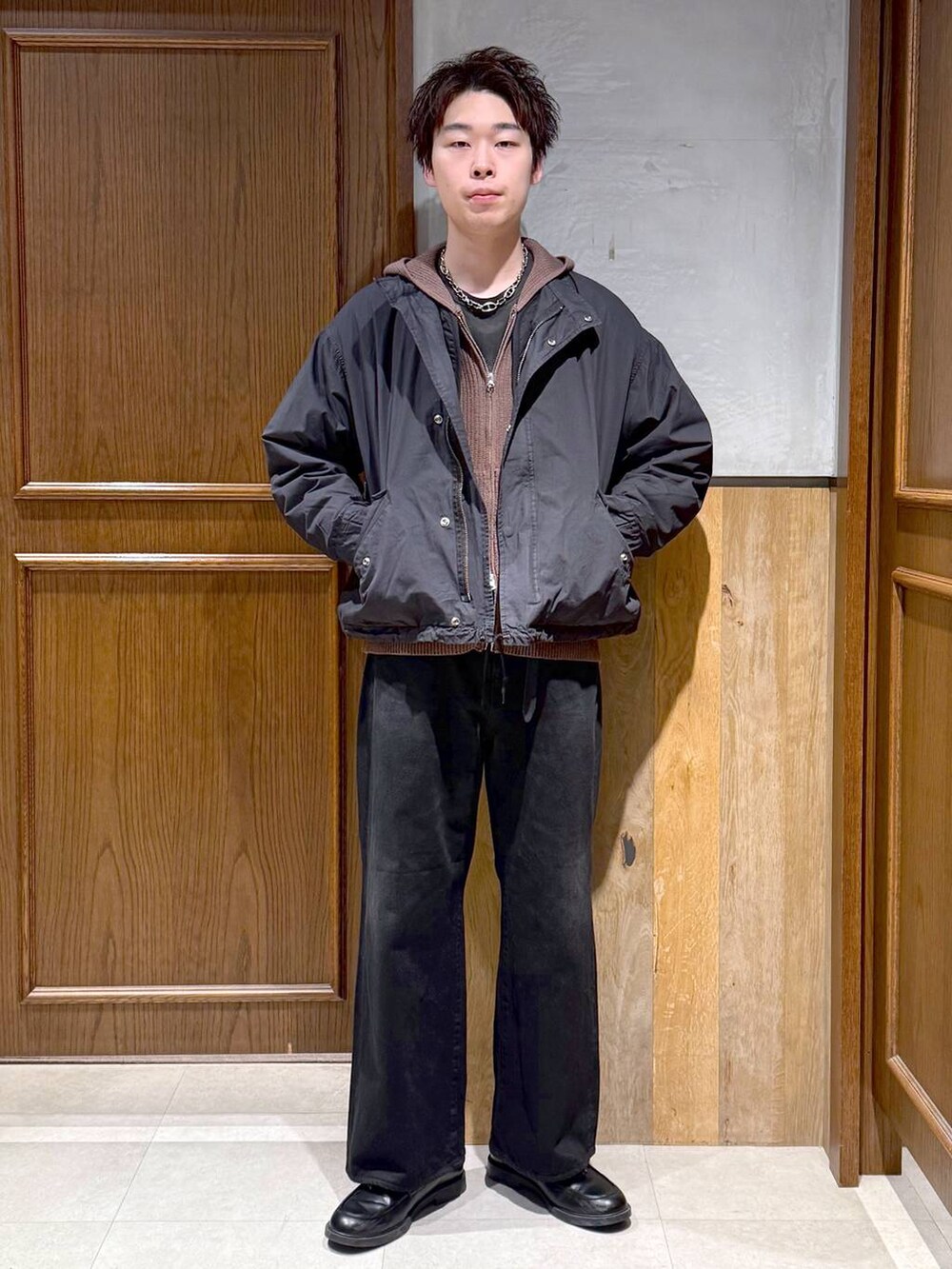 ブラック系のデニムパンツ、ブラック系のモッズコート、ブラウン系のニット/セーターを着用したメンズの冬コーディネートの2枚目の写真