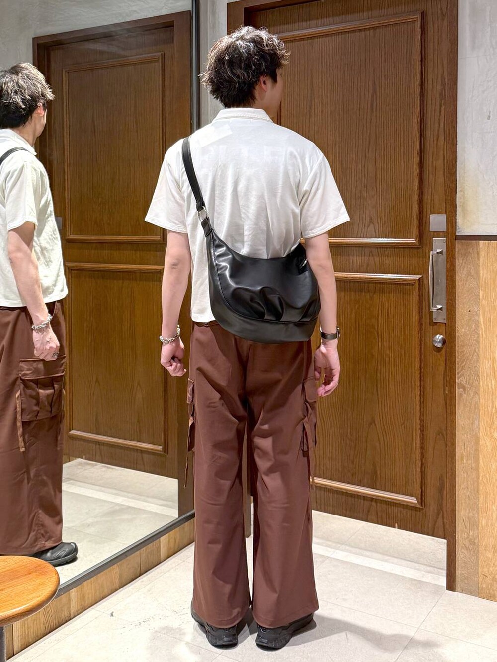 ブラック系のショルダーバッグ、イエロー系のスラックス、ホワイト系のTシャツ/カットソーを着用したメンズの春コーディネートの5枚目の写真
