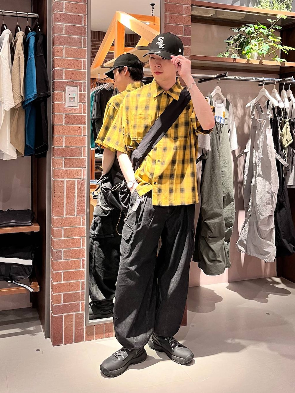 グレー系のデニムパンツ、ブラック系のショルダーバッグ、イエロー系のシャツ/ブラウスを着用したメンズの夏コーディネートの2枚目の写真