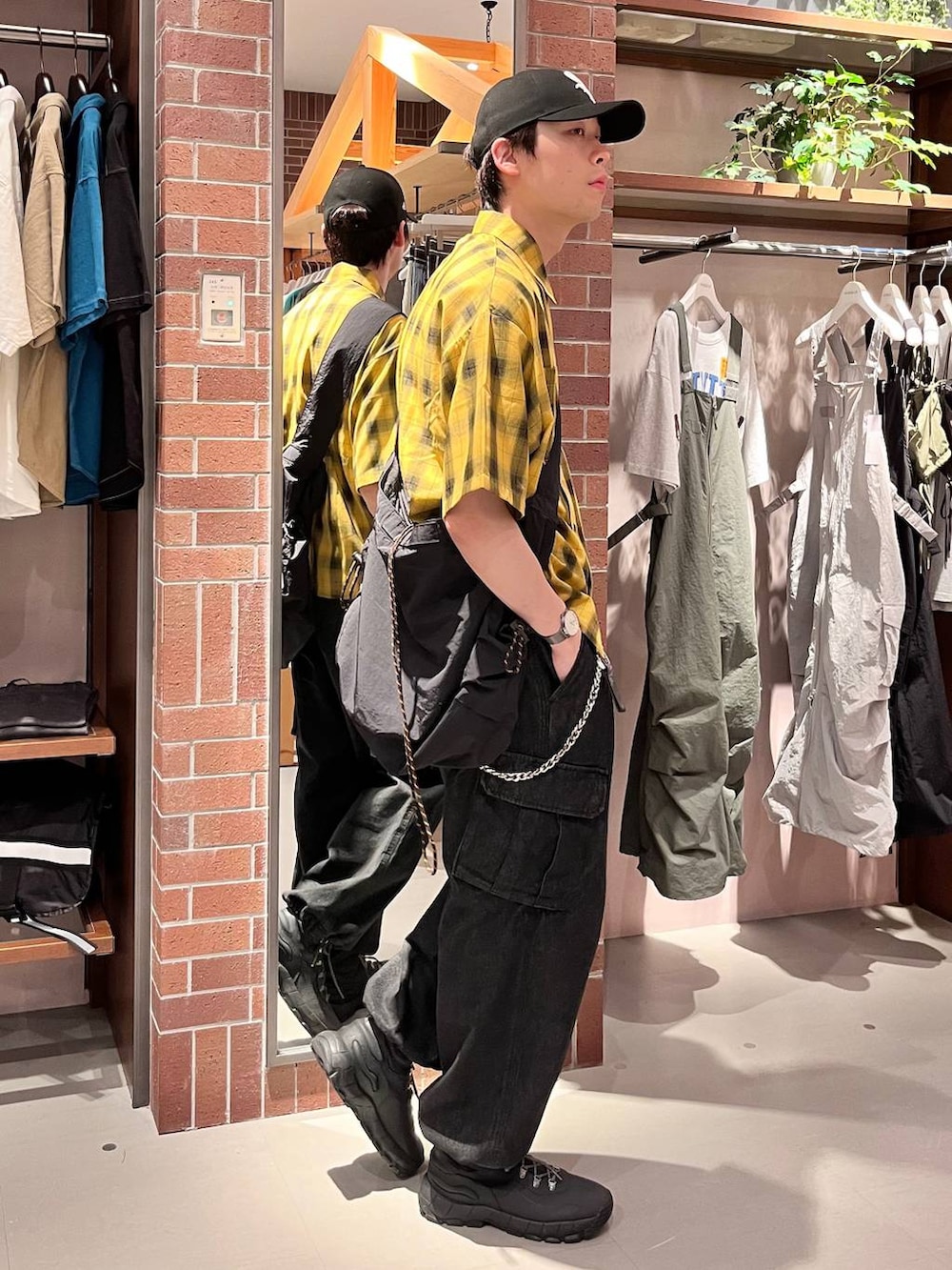 グレー系のデニムパンツ、ブラック系のショルダーバッグ、イエロー系のシャツ/ブラウスを着用したメンズの夏コーディネートの3枚目の写真