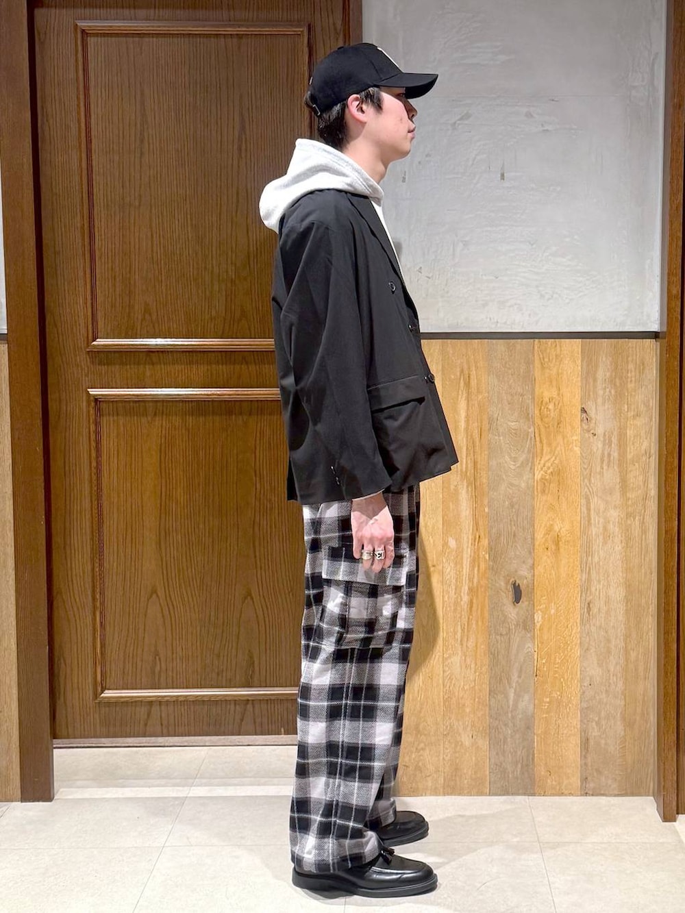 ブラック系のテーラードジャケット、グレー系のカーゴパンツ、グレー系のパーカーを着用したメンズの冬コーディネートの5枚目の写真