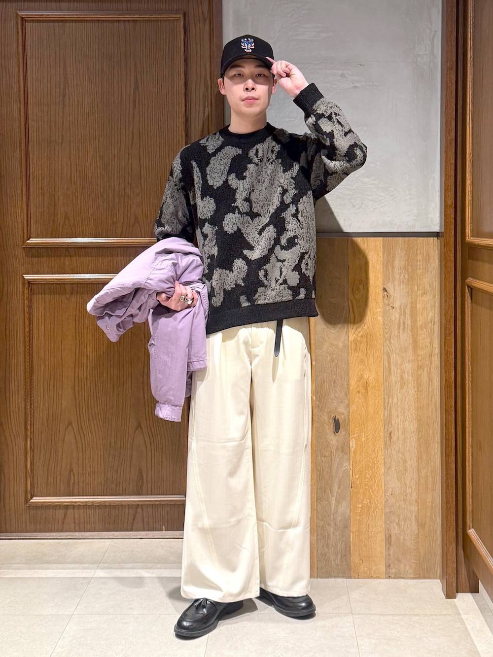 ホワイト系のスラックス、ブラック系のニット/セーターを着用したメンズの冬コーディネートの2枚目の写真