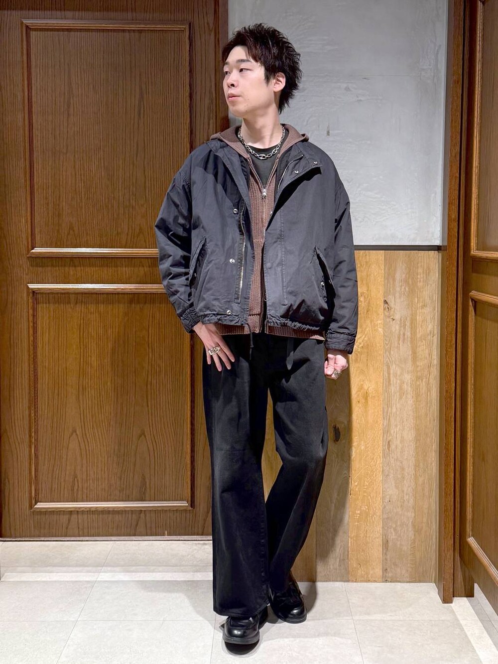 ブラック系のデニムパンツ、ブラック系のモッズコート、ブラウン系のニット/セーターを着用したメンズの冬コーディネートの3枚目の写真