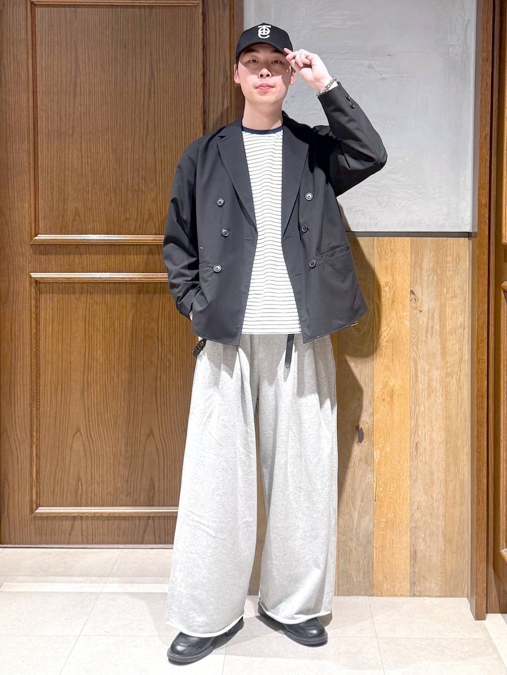 ブラック系のテーラードジャケット、ホワイト系のTシャツ/カットソー、グレー系のスウェットパンツを着用したメンズの春コーディネートの3枚目の写真