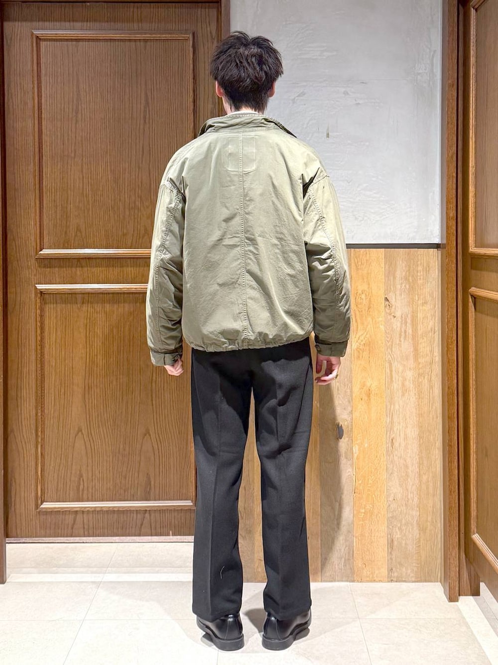 グリーン系のモッズコート、ブラック系のスラックス、ホワイト系のシャツ/ブラウスを着用したメンズの冬コーディネートの5枚目の写真