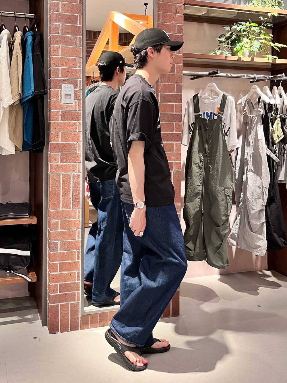 ブルー系のデニムパンツ、ブラック系のTシャツ/カットソー、パープル系のネックレスを着用したメンズの夏コーディネートの4枚目の写真