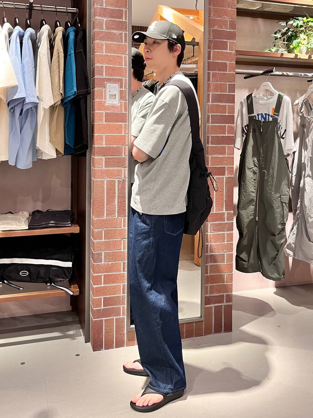 ブルー系のデニムパンツ、ブラック系のショルダーバッグ、グレー系のTシャツ/カットソーを着用したメンズの夏コーディネートの6枚目の写真