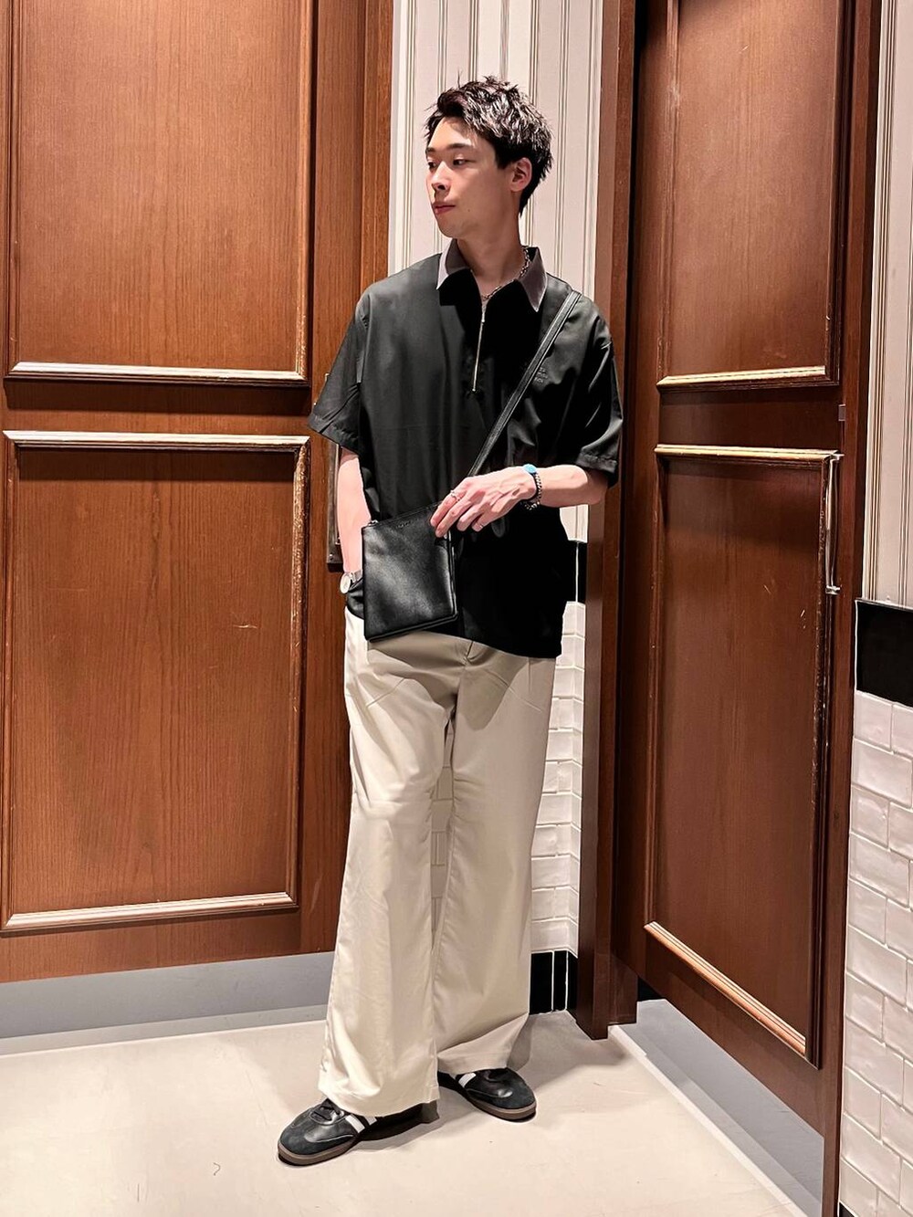 ホワイト系のスラックス、ブラック系のシャツ/ブラウス、ブラック系のショルダーバッグを着用したメンズの夏コーディネートの2枚目の写真
