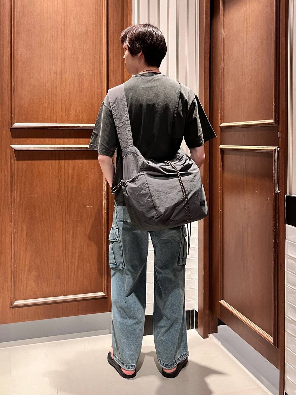 ブラック系のサンダル、ブルー系のデニムパンツ、ブラック系のショルダーバッグを着用したメンズの夏コーディネートの6枚目の写真