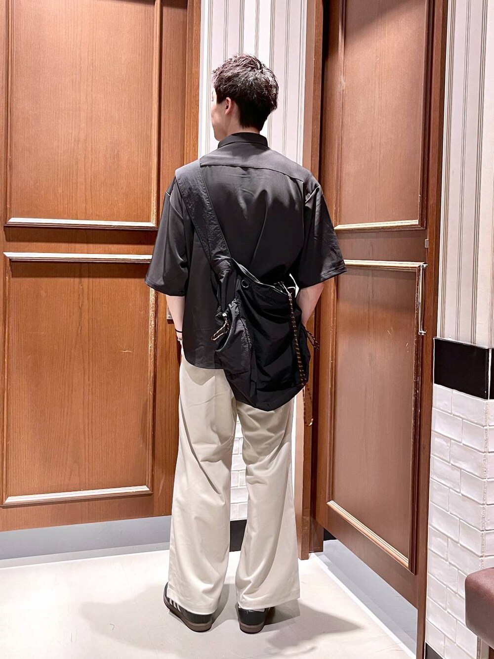 ホワイト系のスラックス、ブラック系のシャツ/ブラウス、ブラック系のショルダーバッグを着用したメンズの夏コーディネートの5枚目の写真