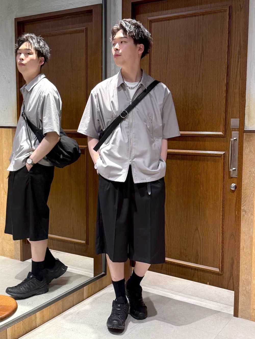 ブラック系のショルダーバッグ、ブラック系のスラックス、ホワイト系のTシャツ/カットソーを着用したメンズの春コーディネートの2枚目の写真