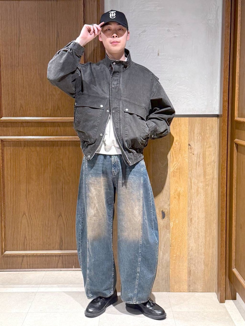 グレー系のスウェット、グレー系のブルゾン、ブルー系のデニムパンツを着用したメンズの春コーディネートの6枚目の写真